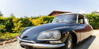 a black sports car parked in a gravel driveway