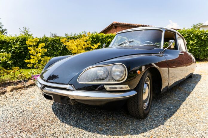a black sports car parked in a gravel driveway