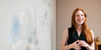 woman in blue tank top standing beside white wall