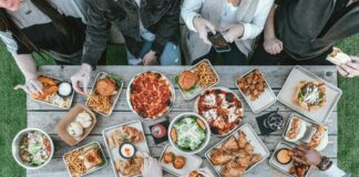 a group of people sitting around a table with food