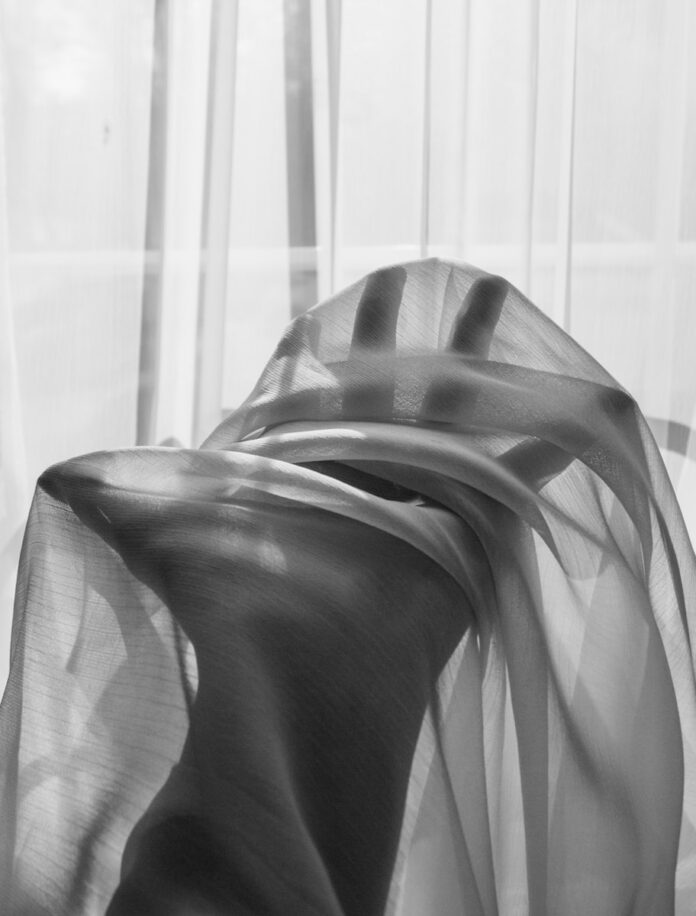 grayscale photo of a person wearing a striped shirt