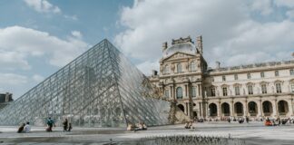 a glass pyramid in front of Louvre