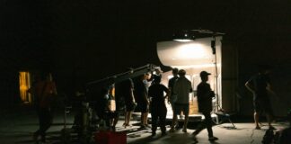 a group of people standing around a camera in the dark