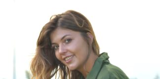 a woman in a green uniform sitting in the grass