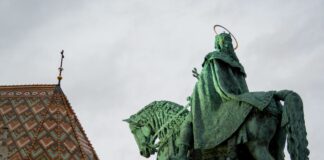 a statue of a man riding a horse next to a building