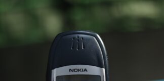 A hand holds a classic nokia phone.