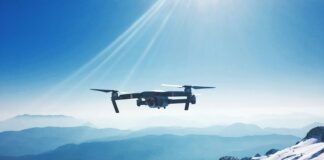 white quadcopter drone flying near snow mountain during daytime