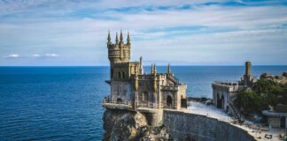 white and brown concrete building near body of water during daytime