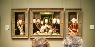 people in black suit jacket standing in front of brown wooden framed wall art