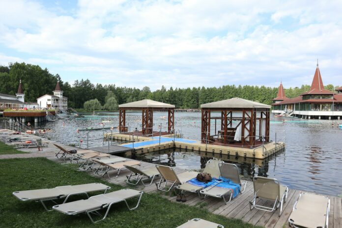A row of lawn chairs sitting next to a body of water