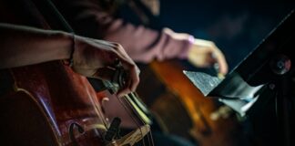 person in brown leather jacket playing brown and black drum set