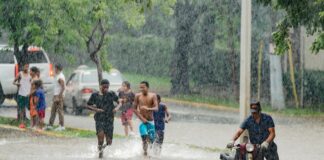 A group of people walking through a flooded street