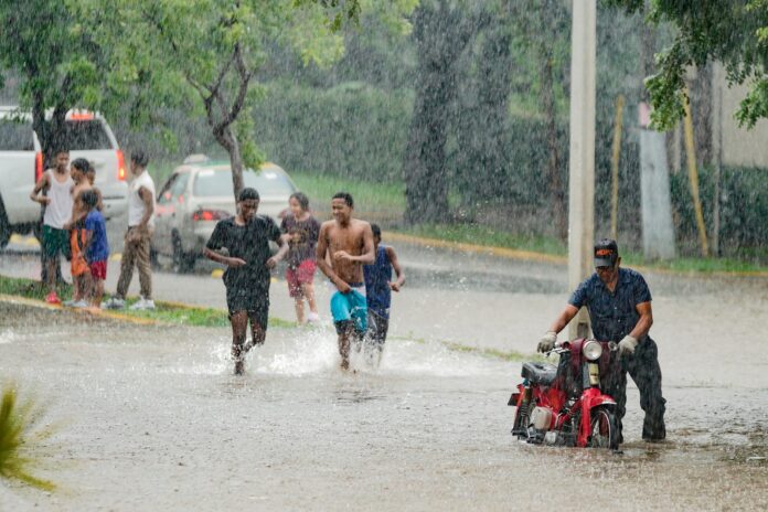 A group of people walking through a flooded street