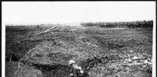 a black and white photo of a man in a trench