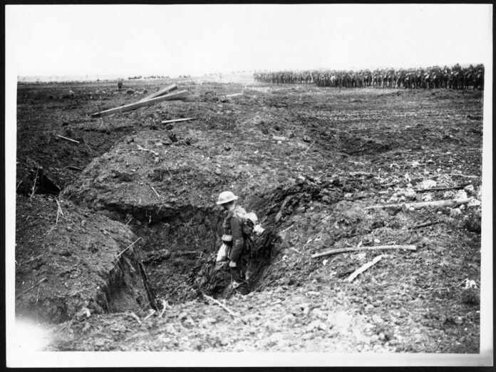 a black and white photo of a man in a trench