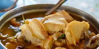 A metal bowl filled with meat and vegetables
