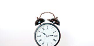 round black and white analog alarm clock