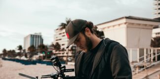 man in black jacket holding black video camera