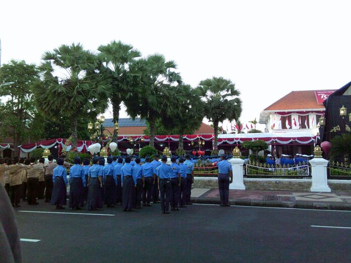 A group of men in blue uniforms standing in front of a crowd