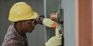 man in brown hat holding black and gray power tool