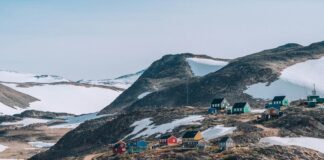 a group of houses on a hill with McMurdo Station in the background