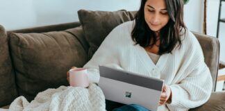 a woman sitting on a couch holding a laptop