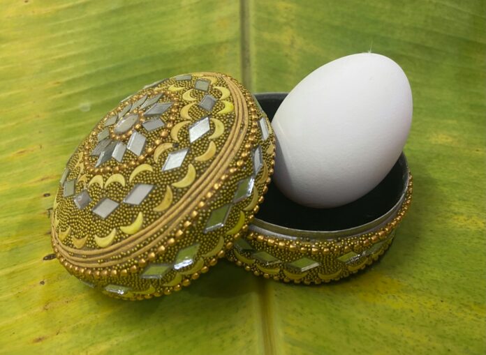 a white egg on a gold chain