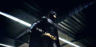 Batman standing under steel roof