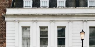 red car parked in front of white building