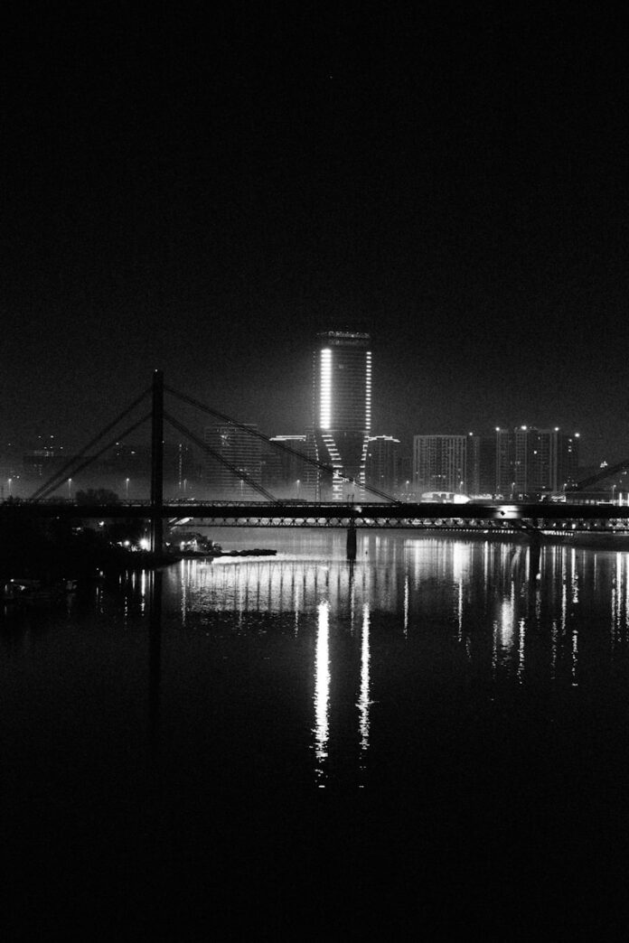 Cityscape with bridge and river at night