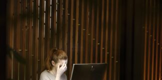 a woman sitting in front of a laptop computer