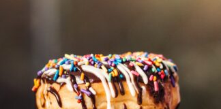 three chocolate-coated donuts with sprinkles
