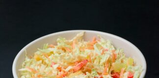 a white bowl filled with coleslaw on top of a table