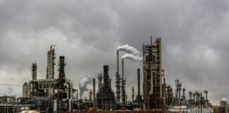 factories with smoke under cloudy sky
