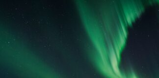 The aurora bore is reflected in the water