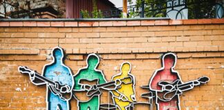 man in blue shirt and black pants standing on brown wooden ladder