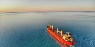 red and white cargo ship at middle of ocean
