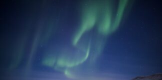 white and brown houses under green sky during night time
