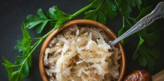 a wooden bowl filled with rice next to a spoon