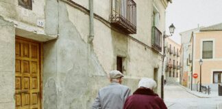 man and woman walking near closed wooden door