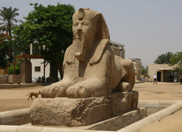 A statue of a seated sphinx in a courtyard