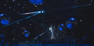 a group of people standing on top of a blue floor