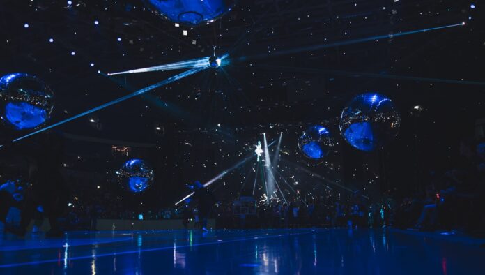 a group of people standing on top of a blue floor