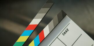 A person holding a clapstick in their hand