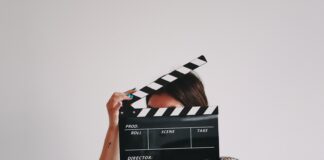 a woman holding a clapper over her face