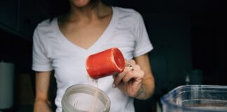 woman in white crew neck t-shirt holding red plastic cup