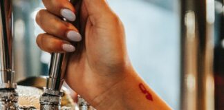 a person is filling a glass of beer