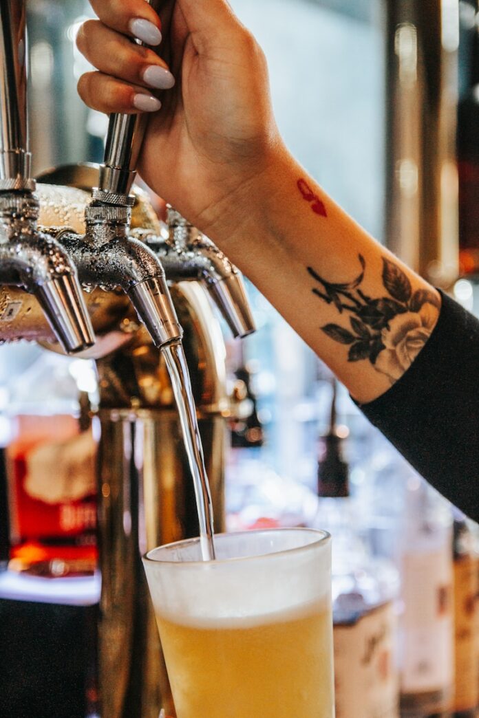 a person is filling a glass of beer