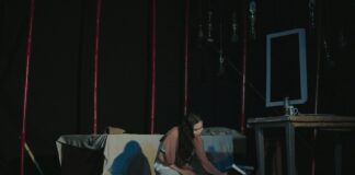 a woman sitting on a couch in a dark room