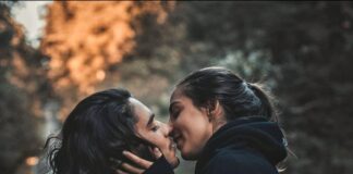 man and woman kissing and standing on road